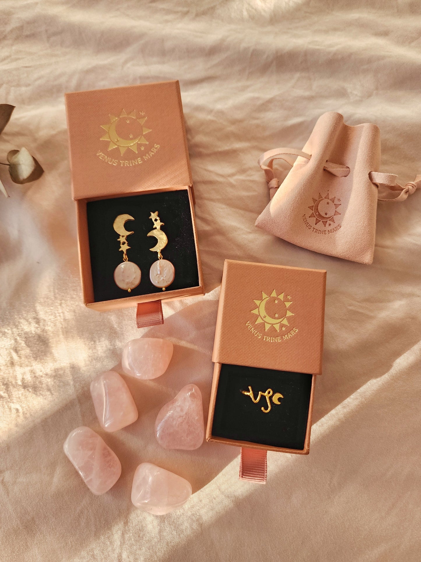 A top-down shot of two terracotta coloured boutique jewellery boxes featuring a handmade Capricorn ring and pink Aurora moon and star gold vermeil earrings with pink baroque pearls. Styled in our Sydney studio with natural rose quartz gemstones and a velvet pouch, this curated set captures a romantic, celestial gift aesthetic.