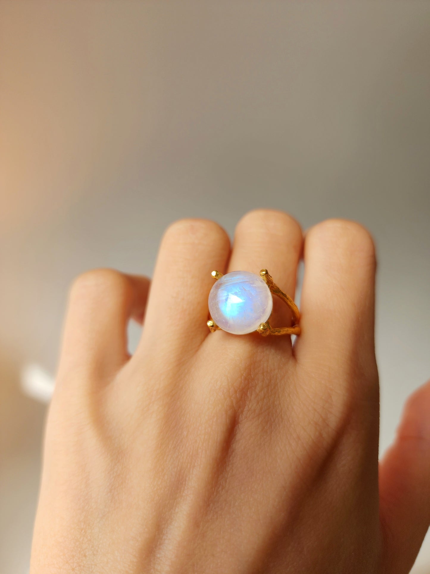 12mm natural moonstone ring in a four prong double gallery mount, artisanal jewellery highlighting the luminous blue glow and hand carved textures.