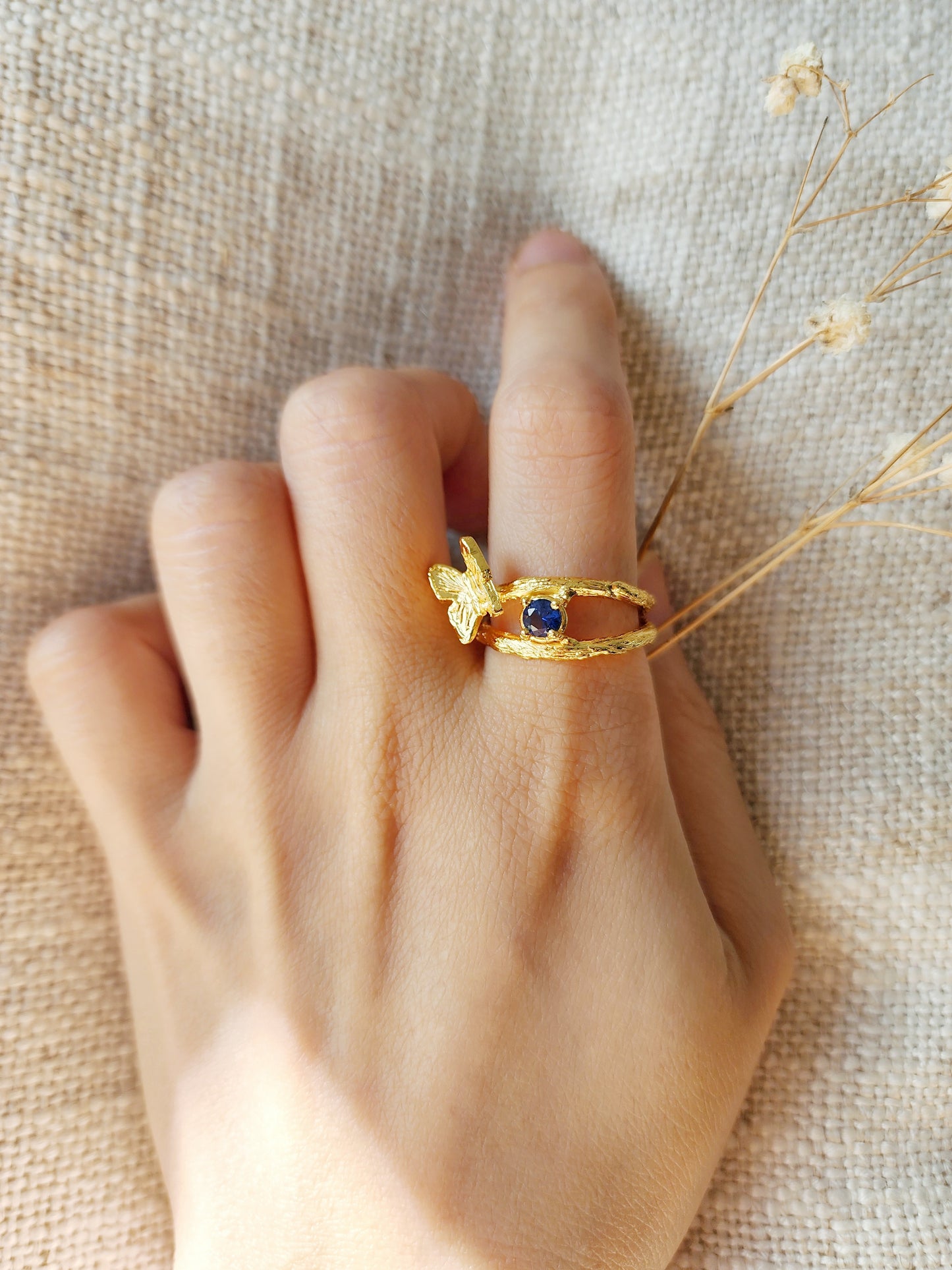 Butterfly ring with natural Sapphire ring, shown on woman's hand to highlight the glow of the 20k gold vermeil and the hand sculpted organic textures from the lost wax jewellery making technique. 