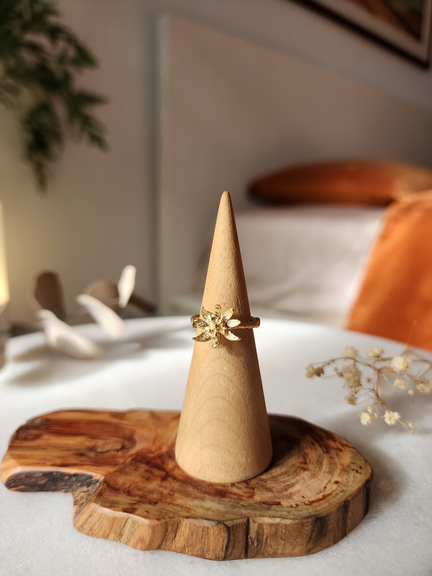 Edelweiss flower ring in 18k gold plating, hand-sculpted in a Sydney studio. Botanical jewellery featuring intricate floral details on a wooden display, styled with dried eucalyptus and baby's breath.