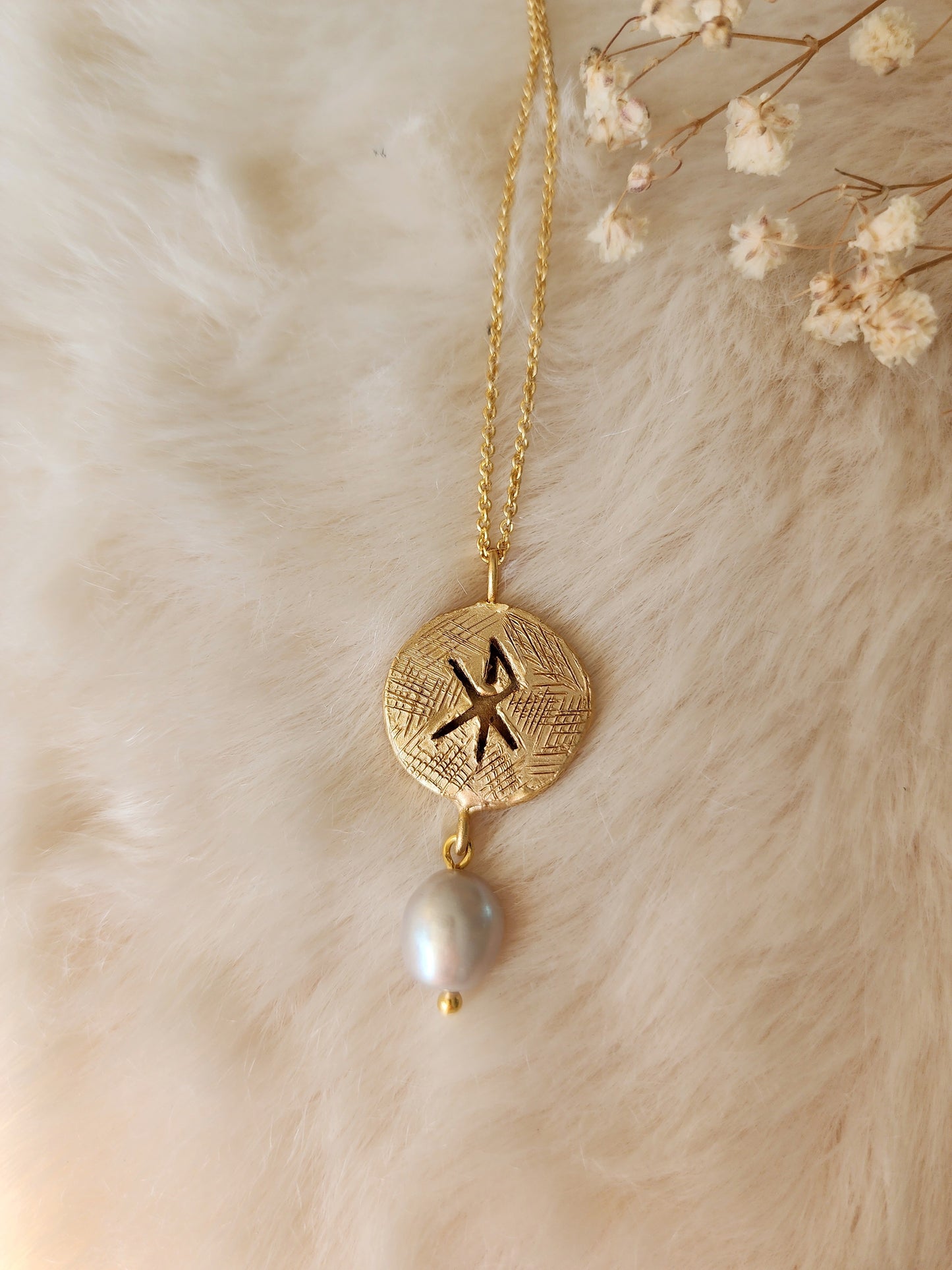 Viking inspired pendant featuring the  norse symbol of love. Crafted in 18k gold vermeil with a grey natural pearl. 
