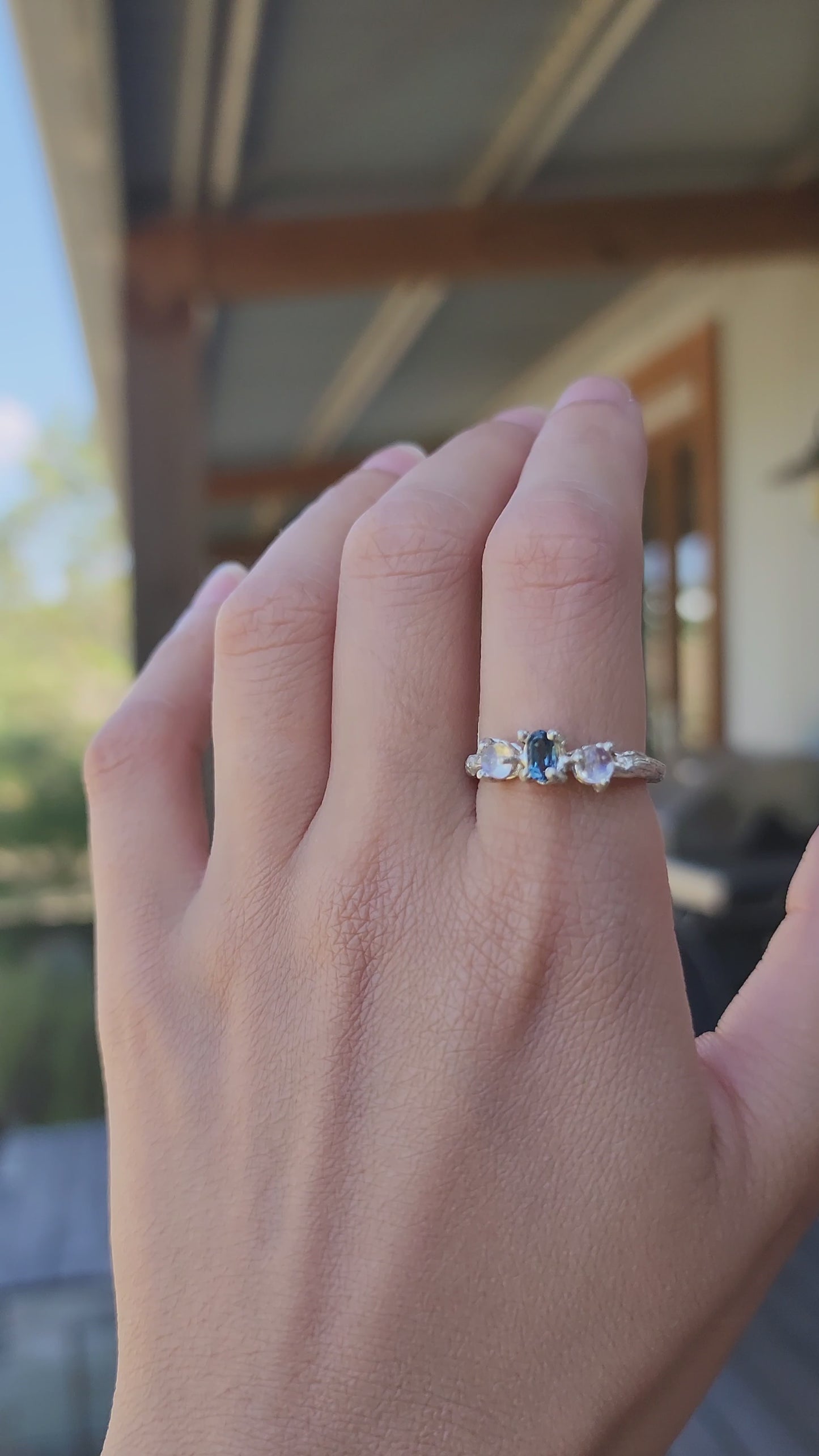 Hand-carved Blue Topaz ring with luminous Moonstone, video revealing the sculptural double gallery setting and molten textures. Handcrafted sterling silver jewellery with an ethereal, nature-inspired glow.