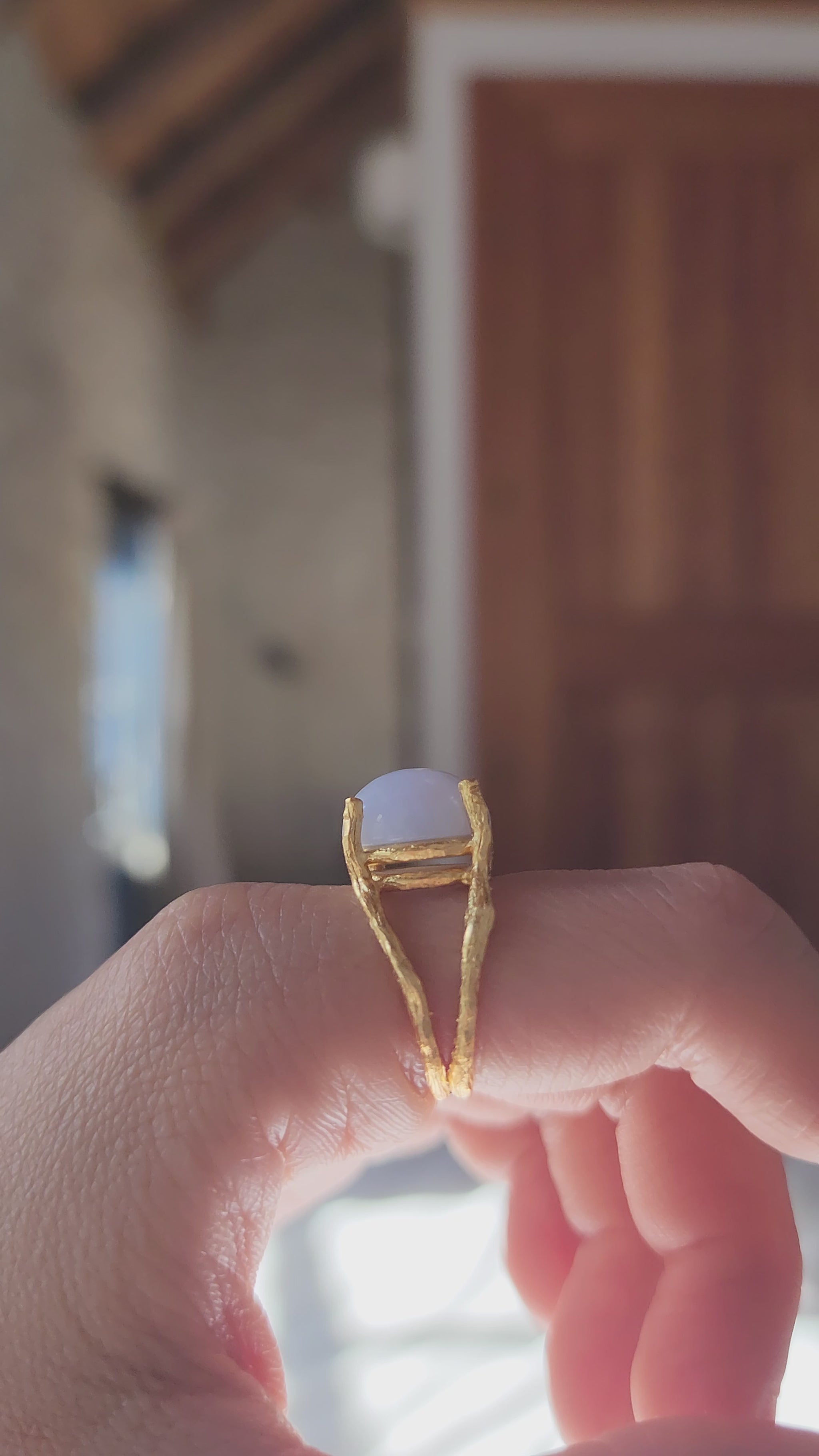 Side profile of blue natural gemstone ring hand sculpted and cast in 20k fine gold plate, shown from the side to highlight the intricate hand carved details of the double gallery basket setting.