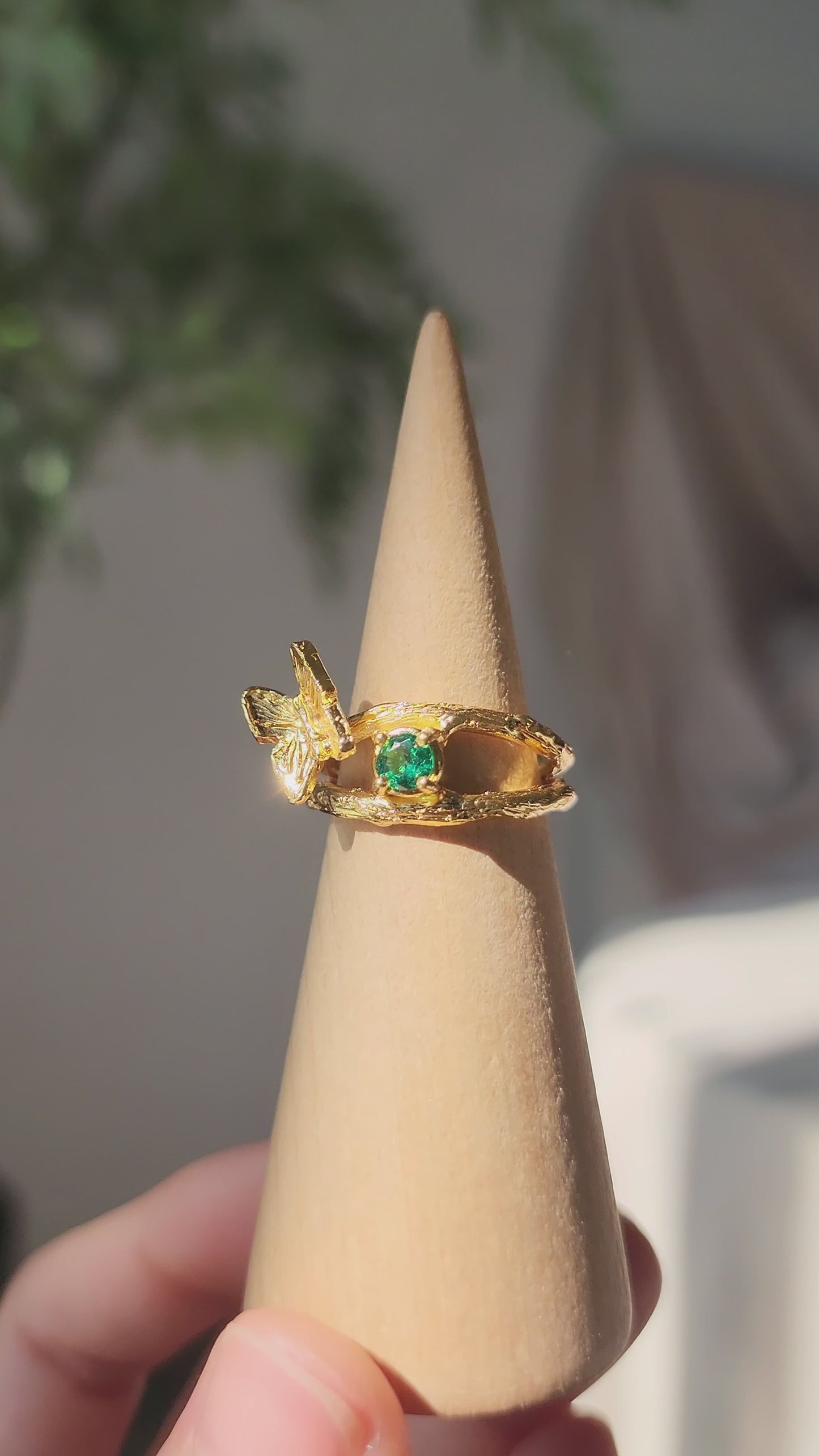 Emerald butterfly ring in 20k gold vermeil, hand-held video rotating to show the 360-degree hand-sculpted details and natural green gemstone.